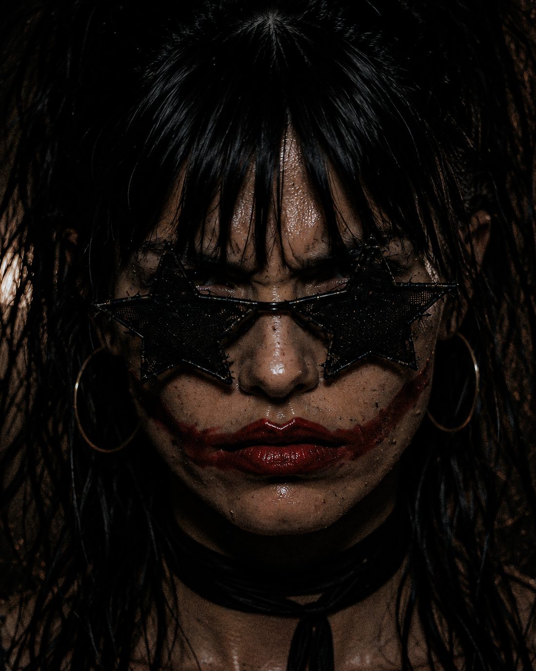 Extreme close-up of ForF's singer: soaked black hair over black star-shaped glasses, red lipstick smeared out past the corners of her mouth.
