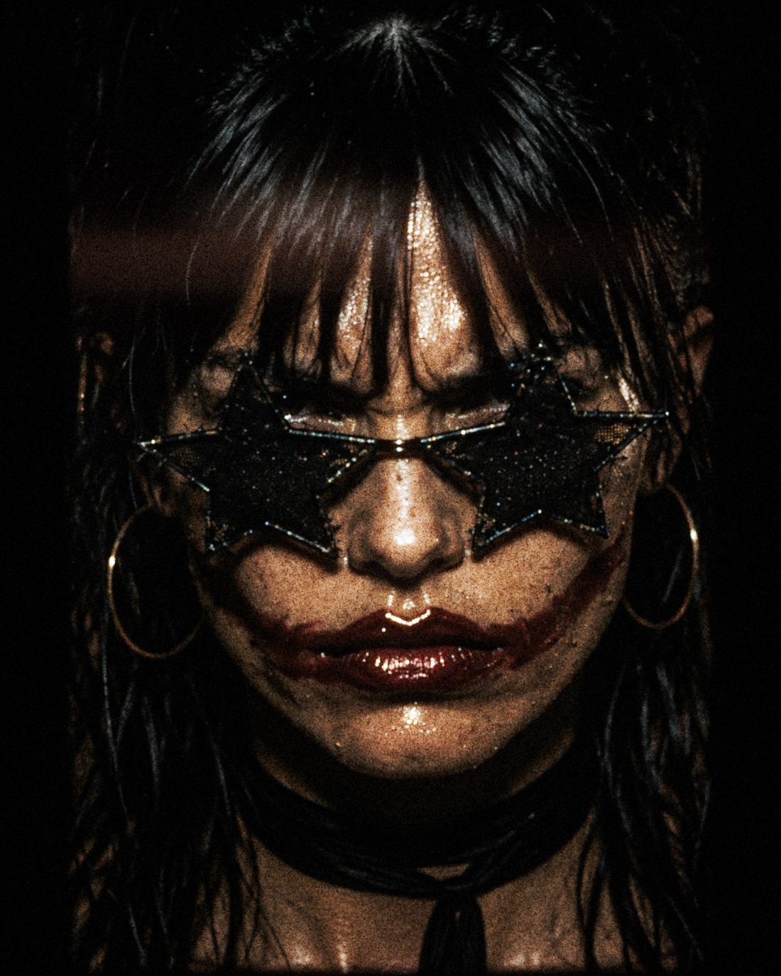 Close-up of ForF's singer smiling behind black star-shaped glasses, red lipstick smeared past the corners of her mouth.